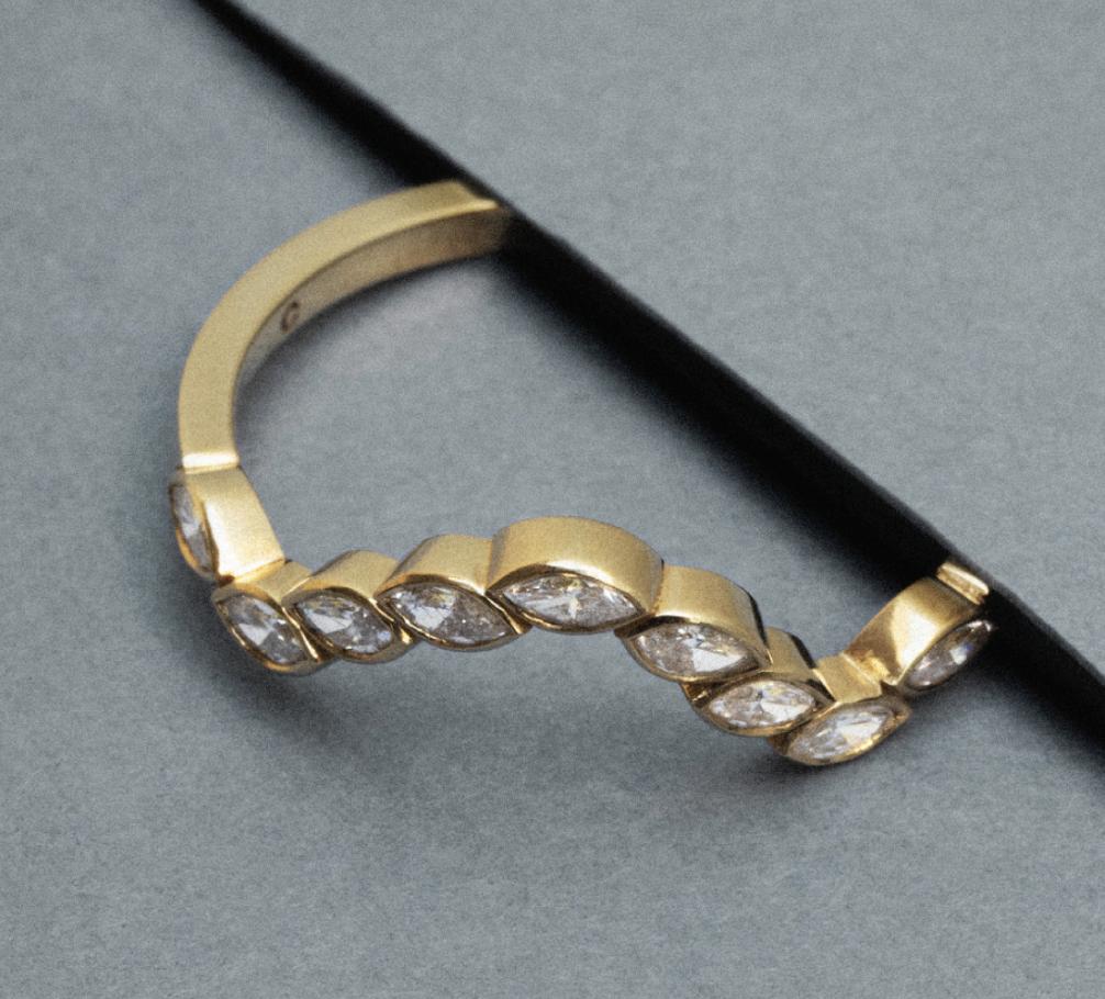 Minimalist diamond ring featuring marquise-cut diamonds set in gold, showcasing elegant geometric design.
