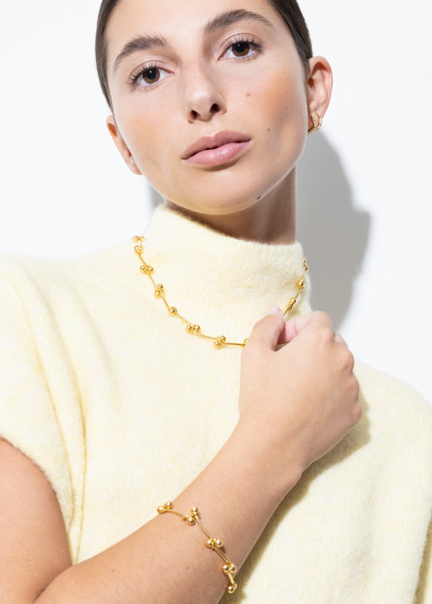 model wearing elin necklace and elin bracelet in gold